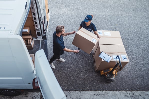  Parcels being carefully loaded onto a van with the great service you get when you use a transportation management system.