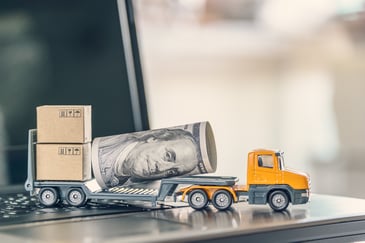 railer truck transports or delivers US USD 100 dollar bill, boxes of goods on a laptop computer