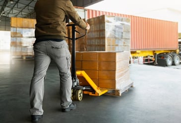 man moving pallets on loading doc